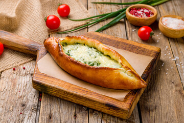 khachapuri with spinach and cheese on the board, georgian cuisine