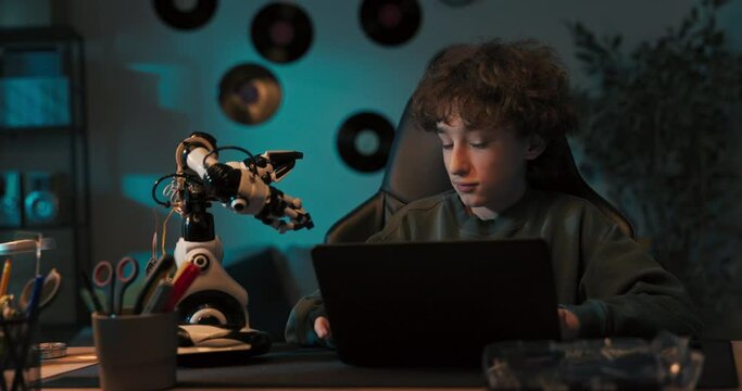 Smiling boy with curly hair spends time playing with toy, assembles robot, child develops passion for electronics.