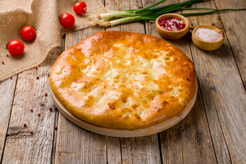 Ossetian pie with cabbage on old wooden table