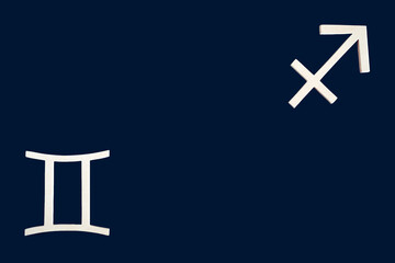 Símbolos astrológicos Géminis- Sagitario sobre fondo oscuro con espacio publicitario . Signos astrológicos opuestos complementarios. Modalidad mutable, elementos aire- fuego. Astrología. Horóscopo  