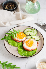 Eggs baked in tomato, arugula leaves and cucumber on a plate. Homemade lunch. Vertical view