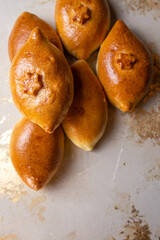 Fried homemade pies with potatoes on the kitchen table. Grandma's recipe. View from above.