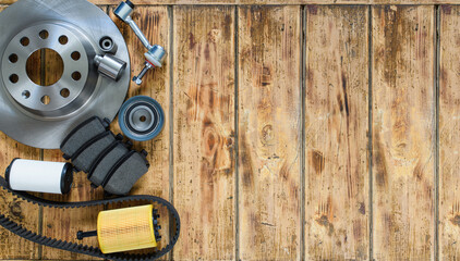 Fototapeta premium Top view of new car parts (brake disc, brake pads, belt, filter) on an old wooden table. To the right is an empty space.
