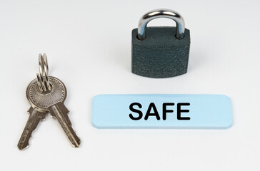 On a white surface there is a lock, keys and a blue sign with the inscription - Safe