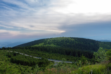 Fototapeta premium Mravenecnik hill , view from upper water reservoir of the pumped storage hydro power plant Dlouhe Strane in Jeseniky Mountains, Czech Republic. During summer evening, sunset with blue sky and clouds.