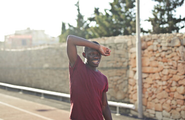 young man wipes the sweat of his forehead with his arm