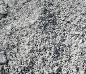Natural chalk mineral background. Small smooth calcite stones are mixed with chalk clay. Calcium in nature. Natural white chalk texture