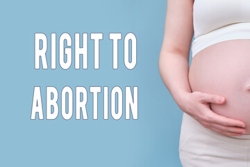 Text right to abortion and tummy pregnant woman, studio shot on a blue background