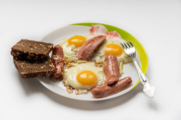 fried eggs on a white plate with bread with seeds.