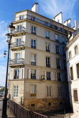 The facades of traditional French houses with typical balconies and windows. Paris.