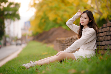 portrait cheerful smiling asian woman  with blooming golden shower flower