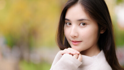 Fototapeta premium portrait cheerful smiling asian woman with blooming golden shower flower