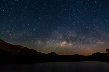Fototapeta premium Beautiful landscape mountains and lake in the night with Milky Way background, Chiang mai , Thailand