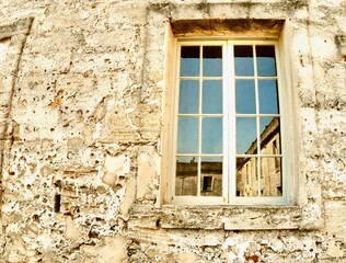 Fototapeta na wymiar Reflection in window, interior courtyard, Castillo de San Marcos, St. Augustine, Florida