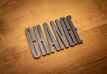 Change in schwarzen Buchstaben auf Holzhintergrund