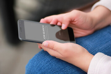 Closeup of woman's hands with black smartphone and job search text