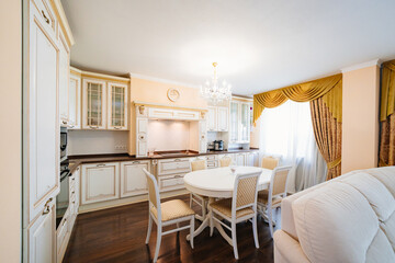 The interior of a large and spacious kitchen-living room in a classic style. 