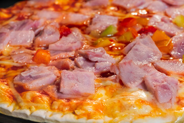 Baked pizza with ham, pepper, cheese, sause on tray in electric oven - close up macro view. Italian cuisine, background, fast food, cooking concept