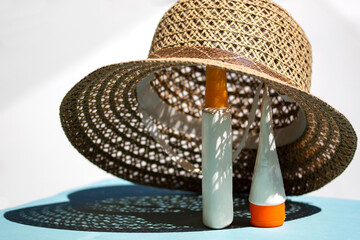 Female  straw hat and body lotion containers for beach holiday