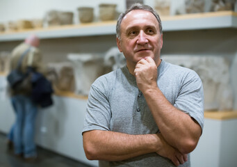 Naklejka premium Portrait of senior man visiting museum of ancient sculpture