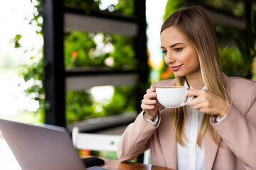 Beautiful business woman using laptop at cafe drink coffee