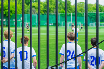 Young Football Players standing on edge of football field. Teenage boys Soccer Team