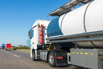 White big modern tanker shipment cargo commercial semi trailer truck moving fast on motorway road...