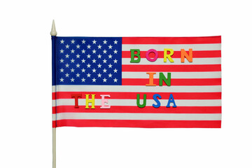 On the USA flag, the text BORN IN THE USA is laid out in multi-colored letters on a white background