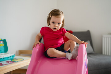 one girl small caucasian child toddler sitting on the slide at home in room childhood and growing up concept copy space
