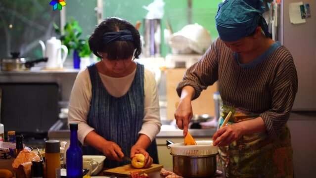 	煮た梅をこす女性