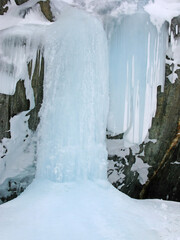 A beautiful landscape of a frozen waterfall in the snowy Norwegian winter day