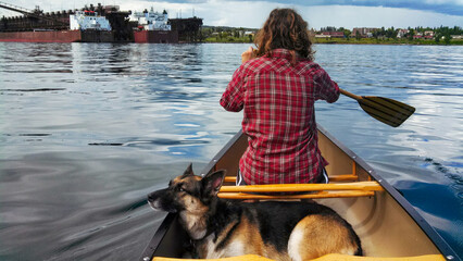 Woman canoeing with her dog on a lake up north