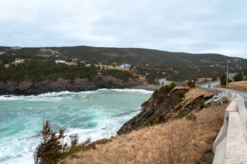 An aerial view of Outer Cove Beach with waves rolling onshore. There are small farmhouses with...