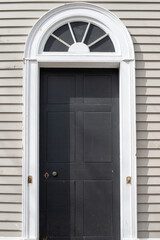 The exterior of a vintage building with beige colored narrow clapboard cape cod siding. There's a...