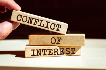 Conflict of interest symbol. Businessman hand. Wooden blocks with words 'Conflict of interest'. - obrazy, fototapety, plakaty
