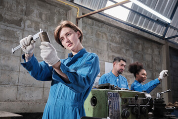 Young Caucasian female industry worker works with metalwork precision tools, lathe machines, and...