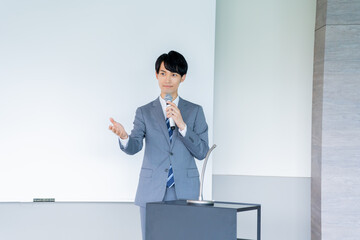マイクを持ち話す30代男性