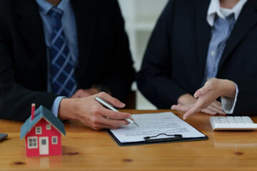 Close up of Business man pointing and signing agreement for buying house. Bank manager and real estate concept.