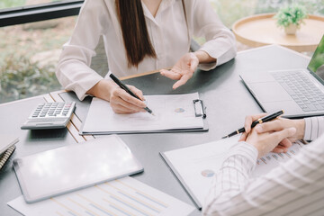Marketer or analytic manager team dressed in suits working with paper charts and laptops at the meeting room.