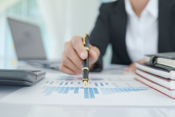 young business working and using laptop, holding smartphone in hand discussing the charts and graphs showing the results of their successful teamwork.