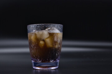 Soda and ice in a clear plastic cup.