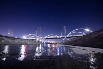 Night view of the 6th Street Bridge passing over the LA River in Downtown Los Angeles, California, USA.