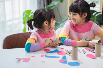 Portrait of a little asian girl cutting a paper in activities on DIY class at School.Scissors cut paper.