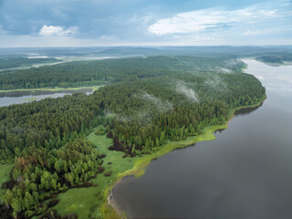 Fototapeta na wymiar Big lake with green shores with morning fog in dawn, aerial landscape. Recreation concept. Aerial view