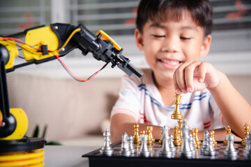 Asian little boy is playing chess with robot machine arm, STEM education E-learning, Funny children learning successful getting a lesson control robot arm, Technology science education concept