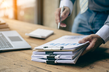 Accountants work with stacks of financial documents and analyze financial data to design modern office strategies and plan new business development ideas. Working on a new startup project