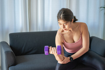 Fototapeta na wymiar A beautiful young Asian woman stretches her arms while watching online exercise exercises on laptop, young woman warming up yoga poses at home in living room. health care lifestyle good health concept