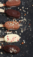 Popsicle ice-cream assortment on dark background.
