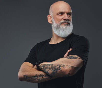 Portrait of self confident old athlete man dressed in black t shirt with tattooed hands.