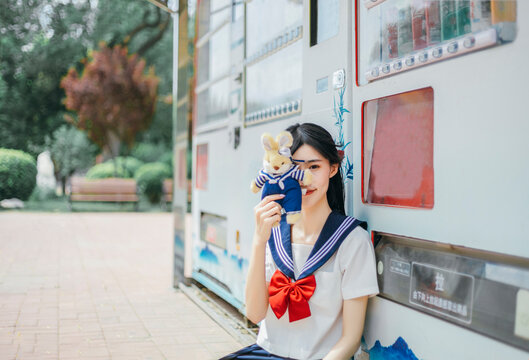 A girl in a Japanese school uniform at an amusement park